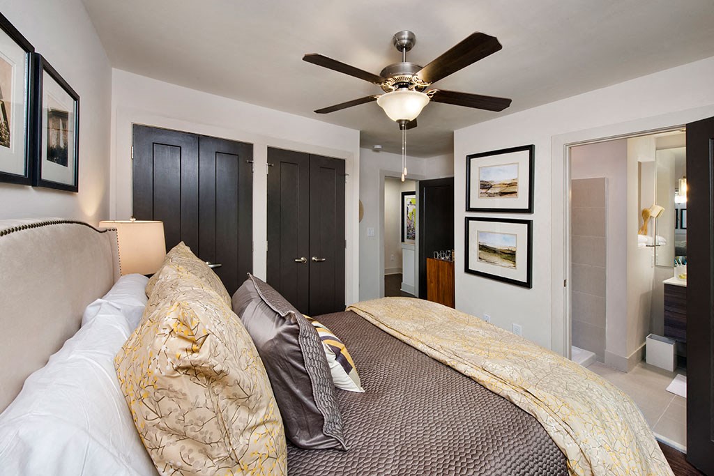 a bedroom with a large bed and a ceiling fan