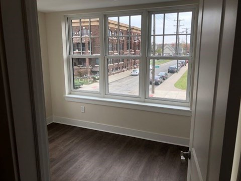 an empty room with a large window overlooking a street