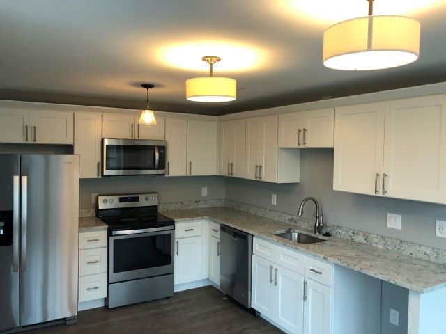 a kitchen with white cabinets and stainless steel appliances