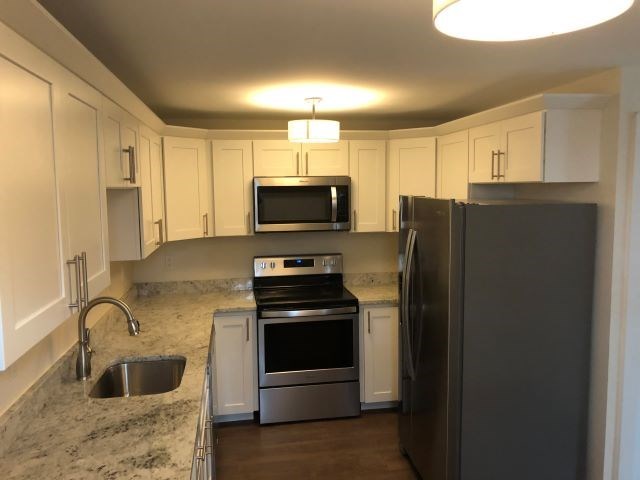 a kitchen with stainless steel appliances and white cabinets