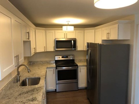 a kitchen with stainless steel appliances and white cabinets