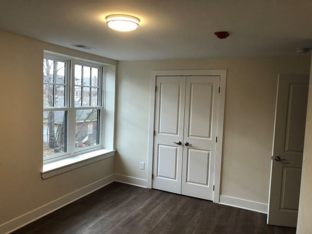 an empty room with a window and a white door