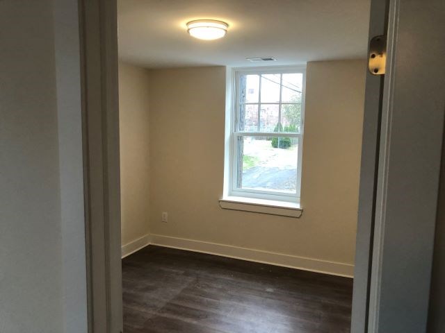 a small room with a window and wooden floors