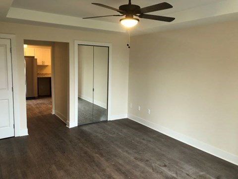 an empty living room with a ceiling fan