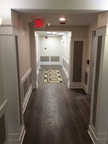 a hallway with wooden floors and a red light on the ceiling