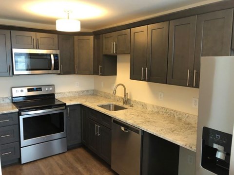 a kitchen with stainless steel appliances and marble counter tops