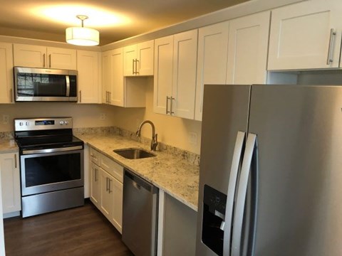 a kitchen with stainless steel appliances and white cabinets