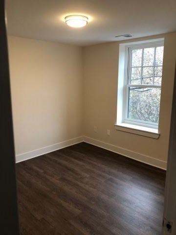 a empty room with a window and wooden floors