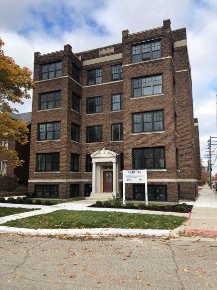 a large brick building with a sign in front of it