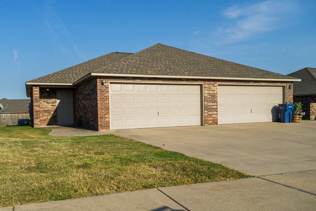 a garage door on a brick house with a driveway