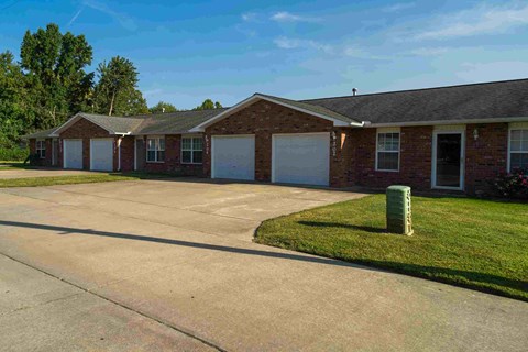a large brick house with white doors and a driveway
