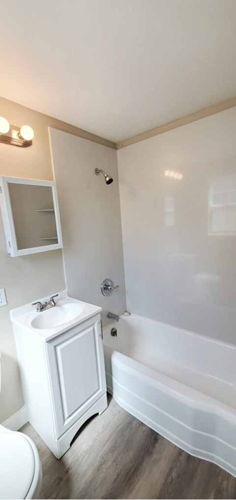 A white bathroom with a white sink and a white tub.