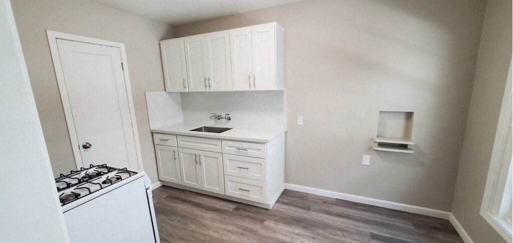 an empty kitchen with a stove and a sink