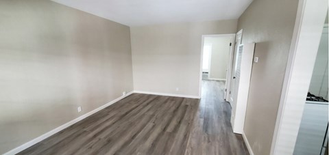 A room with wooden flooring and white walls.