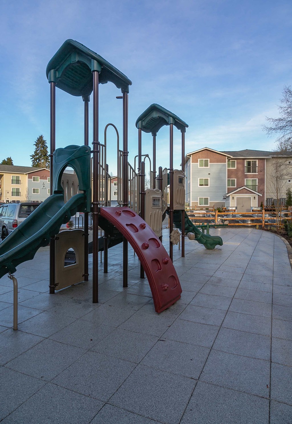 a playground with slides and other equipment in an apartment complex