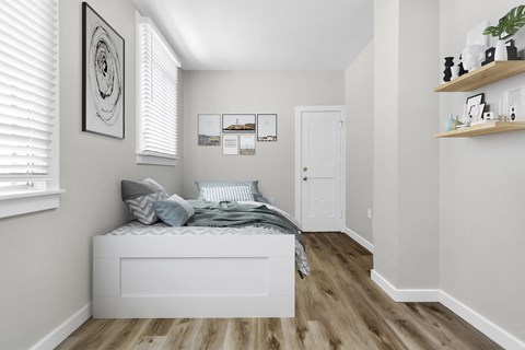 A bedroom with a bed, a shelf with decorative items, and pictures on the wall.