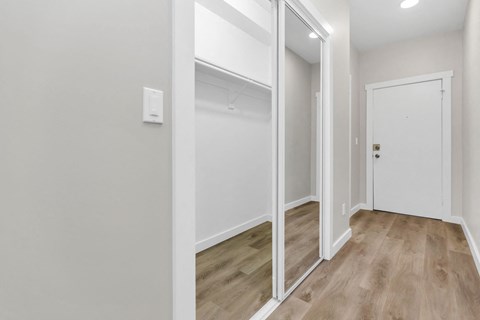 A hallway with a white door and a white wall.