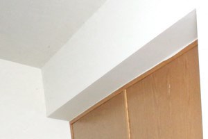 an empty kitchen with white appliances and wooden cabinets