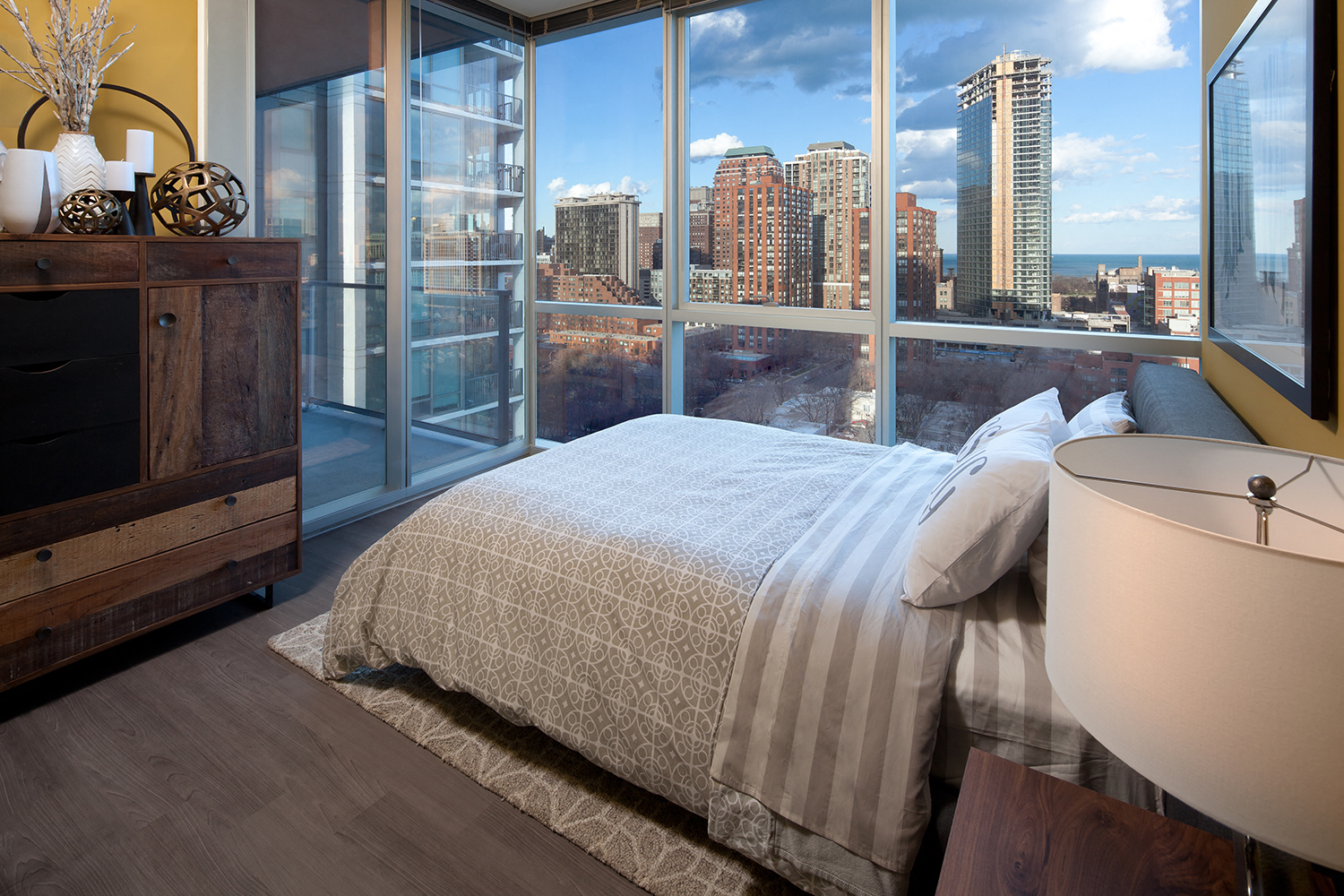 A bedroom with a large bed and a view of the city.