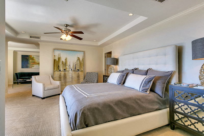 Stunning master bedroom with ceiling fan, plush carpet and lots of natural lighting