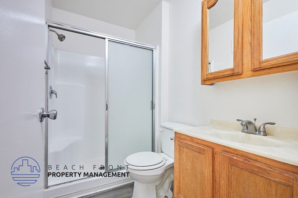 A white toilet sits next to a sink in a bathroom.