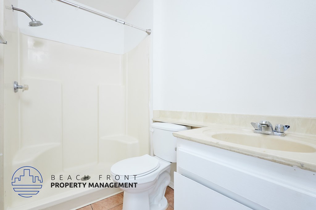 A white toilet sits next to a sink in a bathroom.