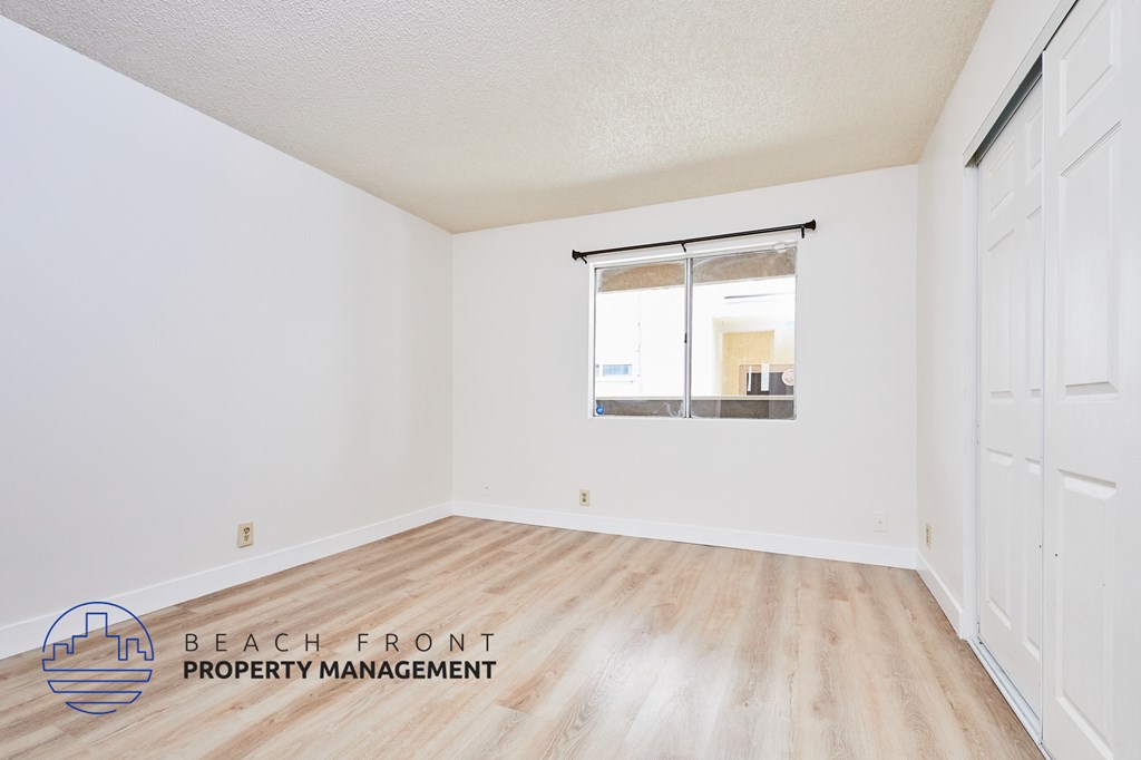 A room with a window and a logo for Beach Front Property Management.
