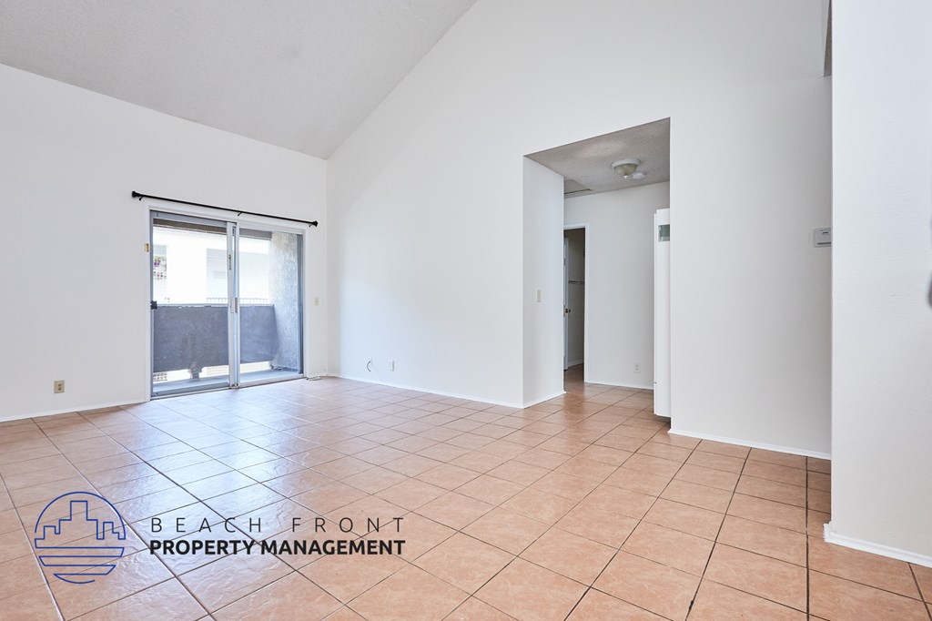 A spacious room with a logo for Beach Front Property Management on the floor.