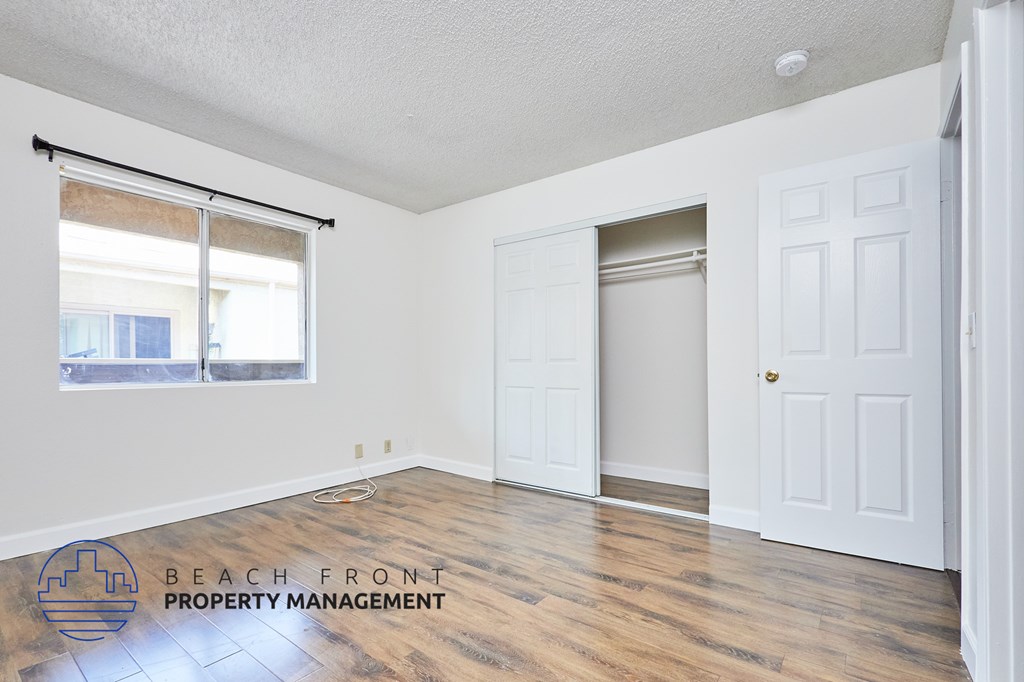 A room with a white door and a window with blinds.