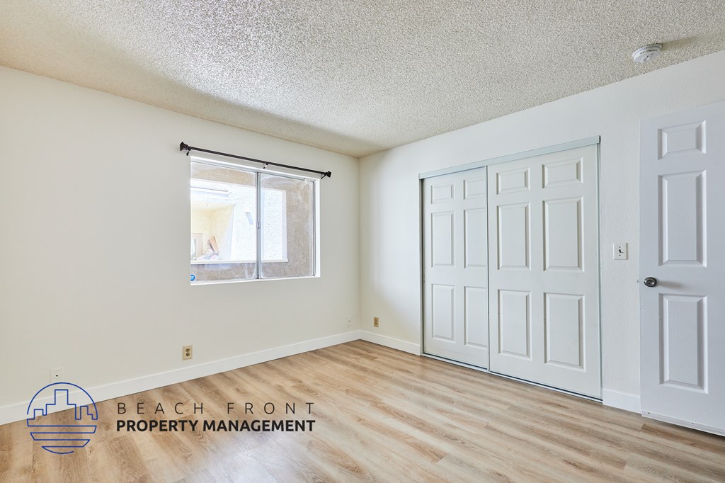 A room with a white door and a window with blinds.