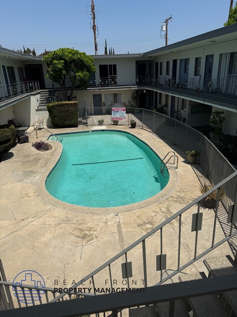 A pool surrounded by a fence and a sign that says "Property Management".