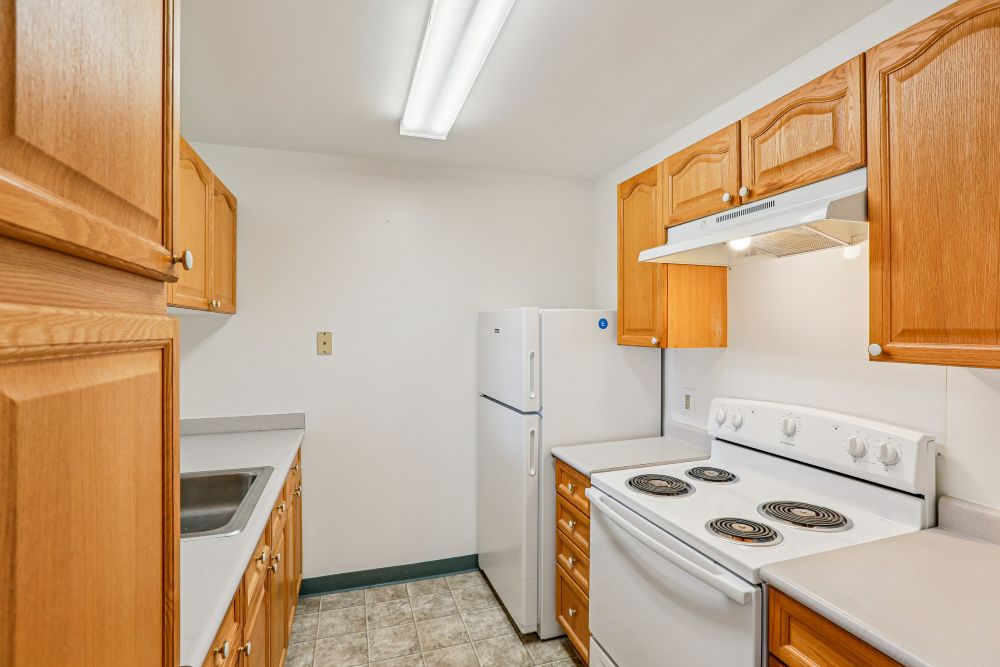 A kitchen with wooden cabinets and white appliances.