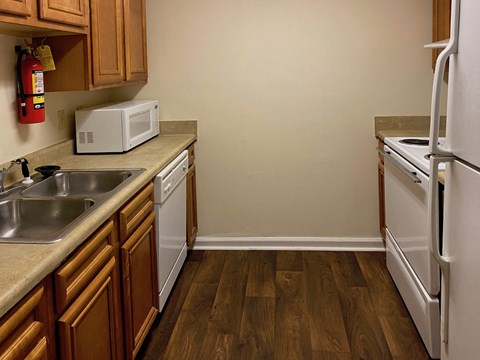 a kitchen with white appliances and wooden cabinets