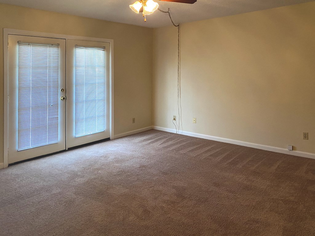 large living room with ceiling fan and french doors to deck