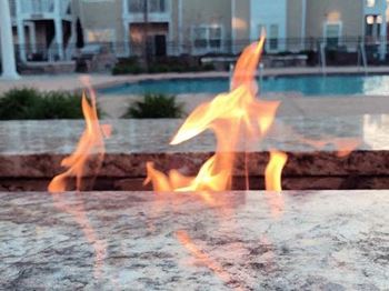 Lit fire pit around pool area at Fenwyck Manor Apartments, Virginia