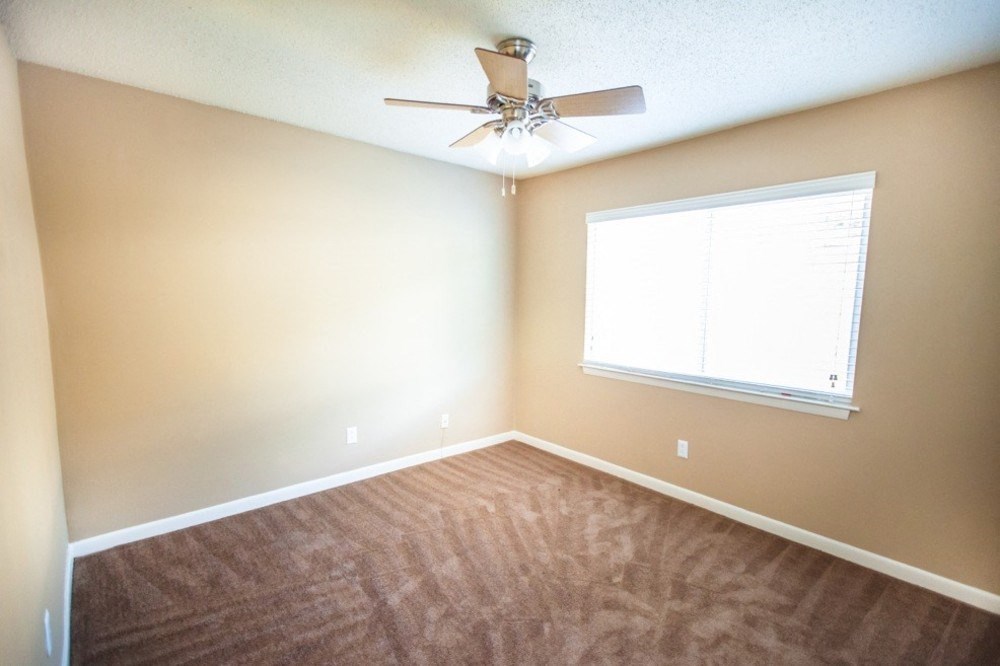 ceiling fan with light kit and large window in bedroom