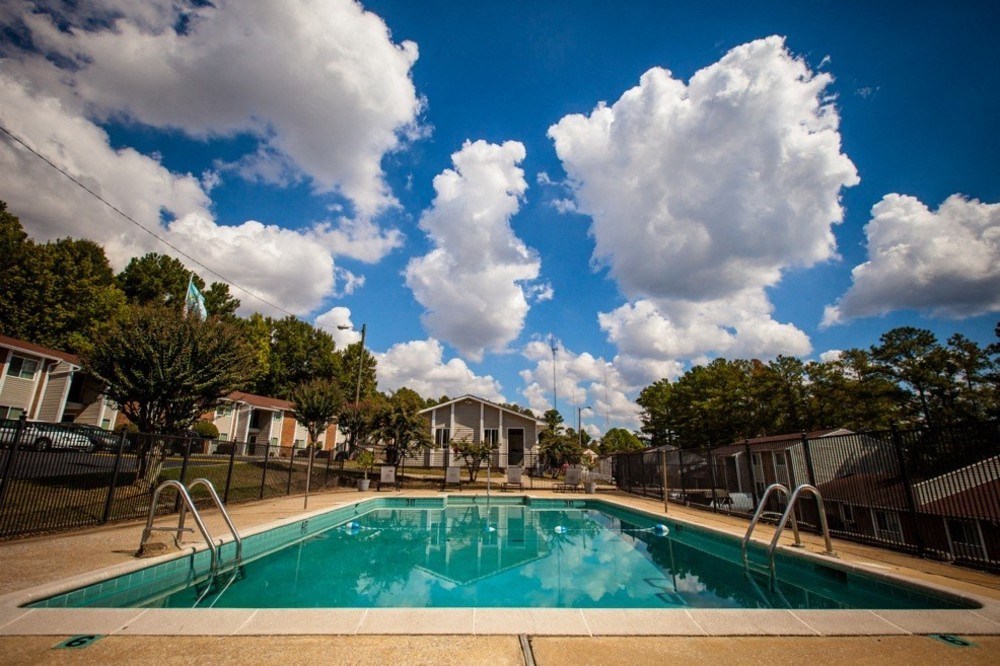 sparkling pool with puffy white clouds in blue sky