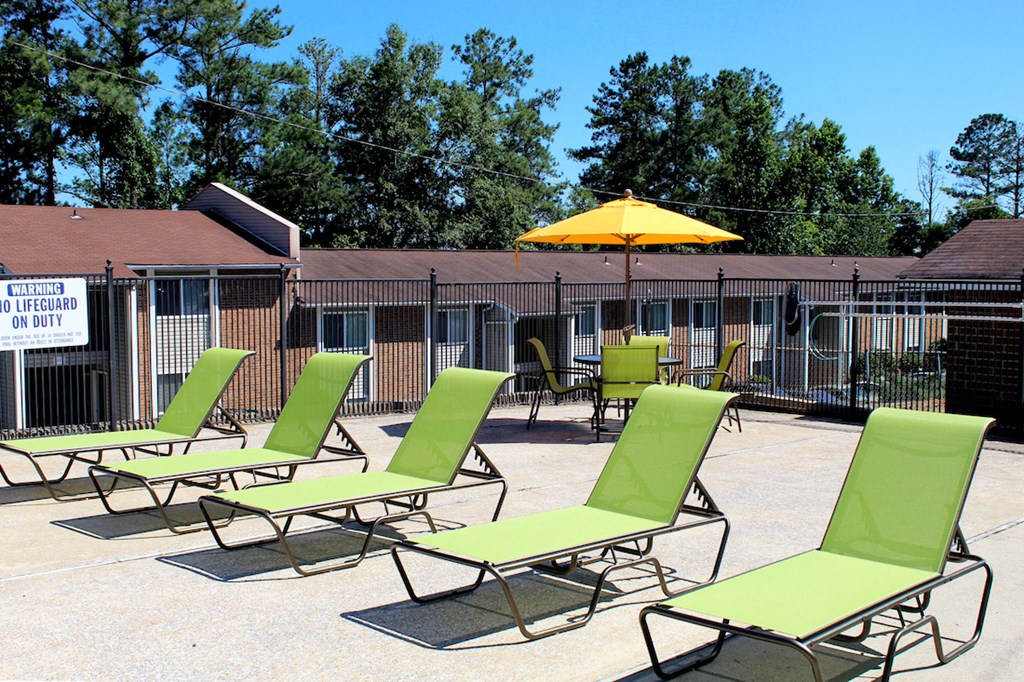 green deck chairs and picnic table with umbrella