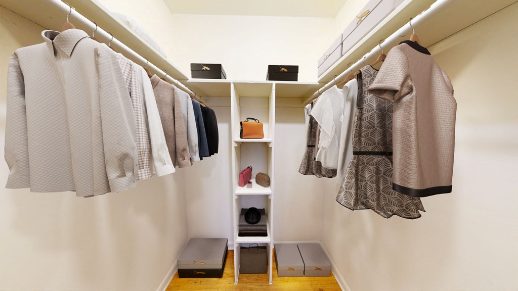 a walk in closet with clothes hanging on a rack and a closet organizer