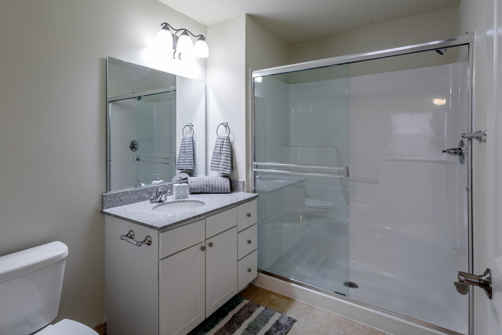 a bathroom with a shower and a sink and a toilet