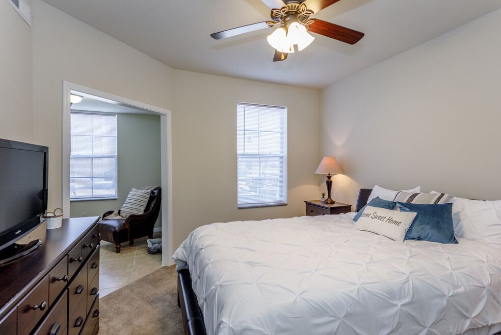 a bedroom with a large bed and a ceiling fan