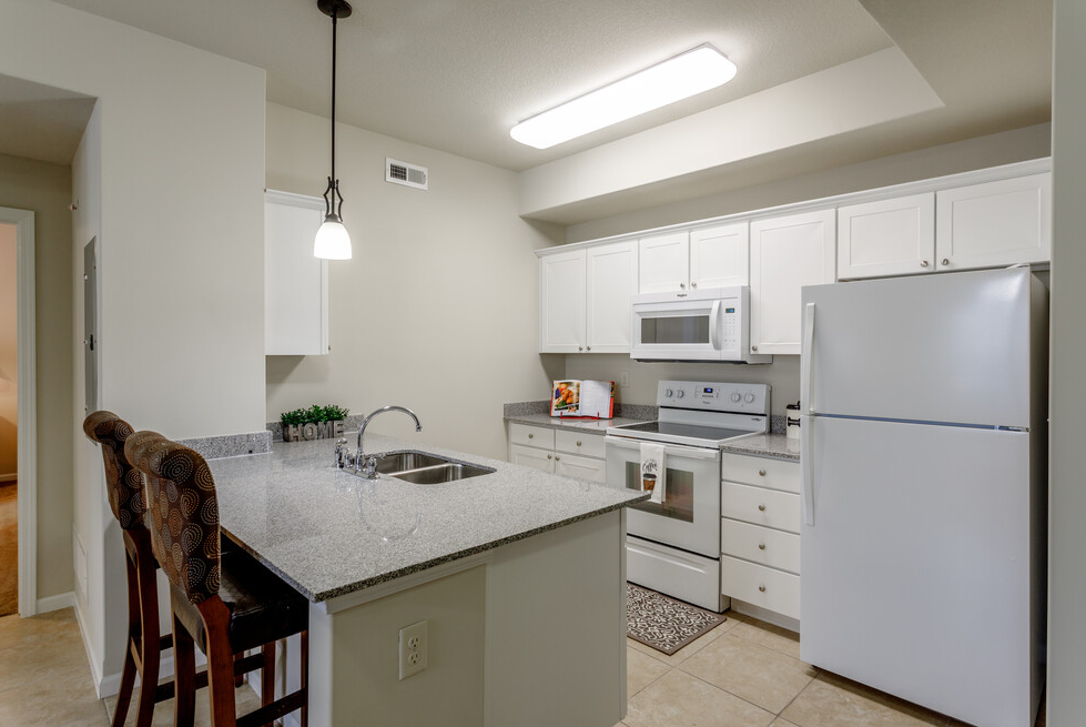 a kitchen with white cabinets and appliances and a counter top
