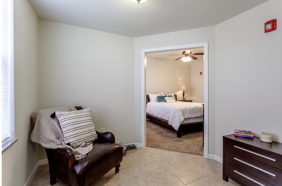 a living room with a chair and a bedroom with a bed