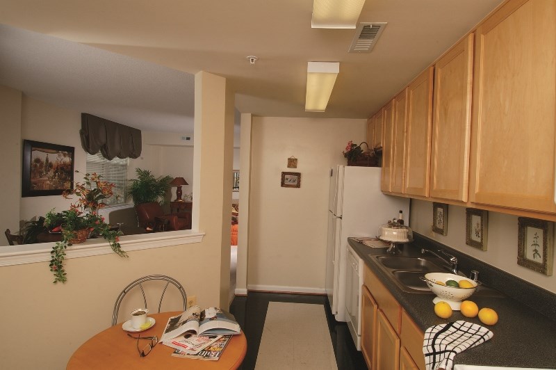 a small kitchen with wooden cabinets and a table