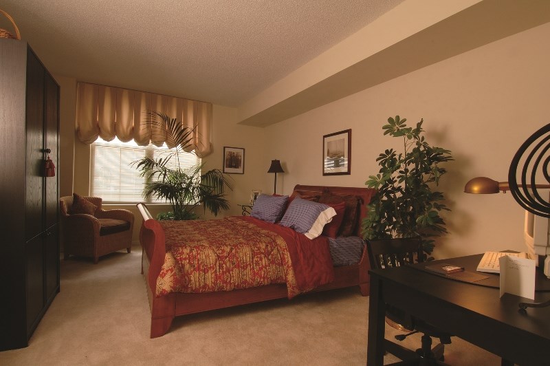 a bedroom with a bed and a desk and a window