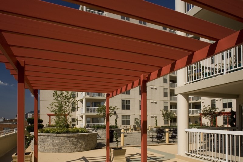 a red covered porch with an apartment building in the background