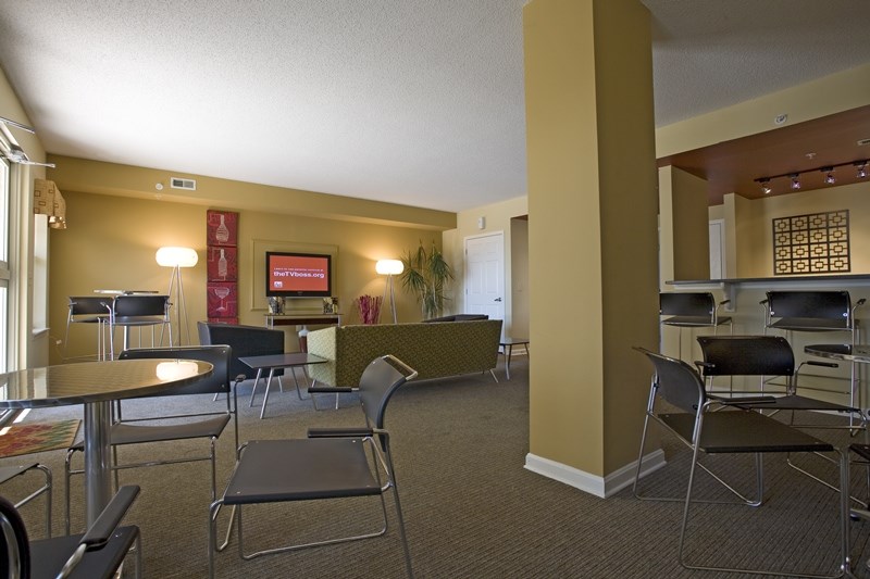 a living room with tables and chairs and a kitchen and dining area