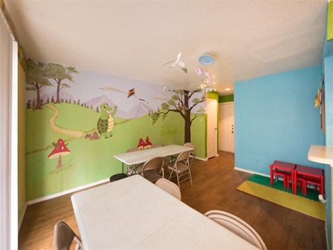 a dining room with a mural on the wall and a table and chairs