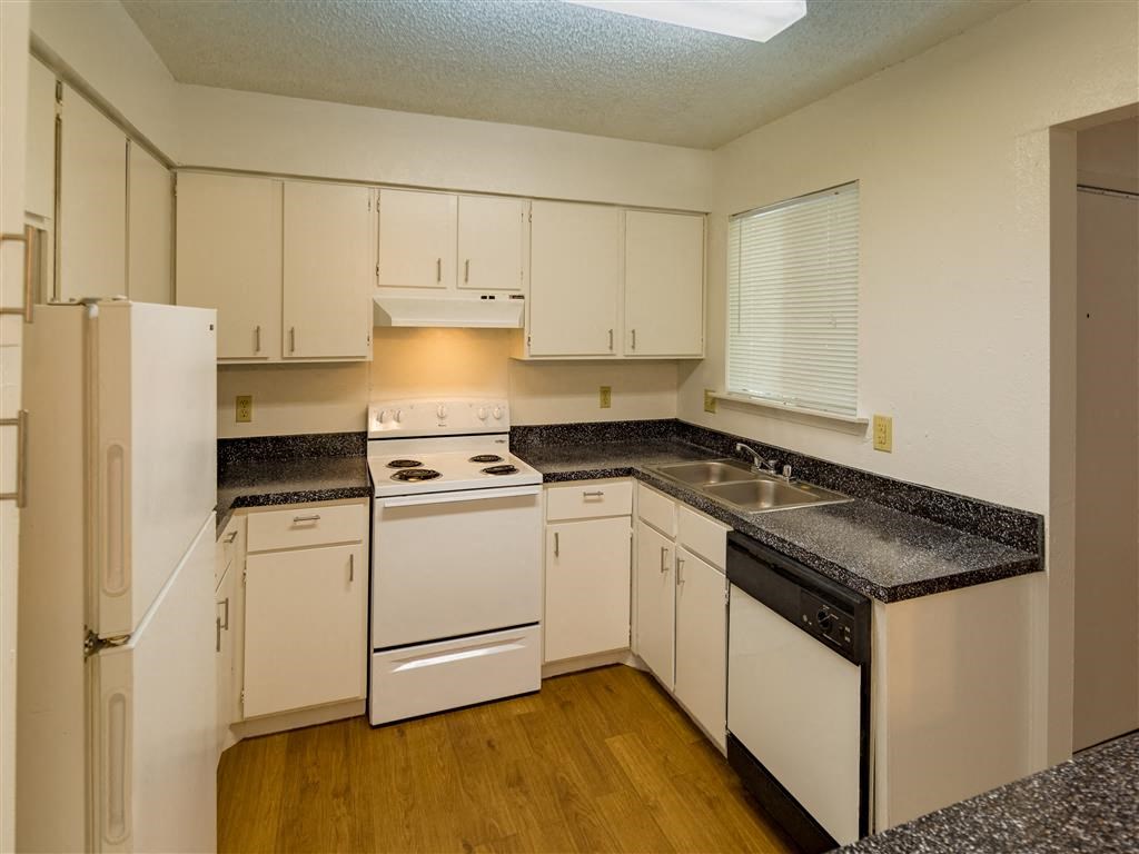a kitchen with white appliances and granite counter tops