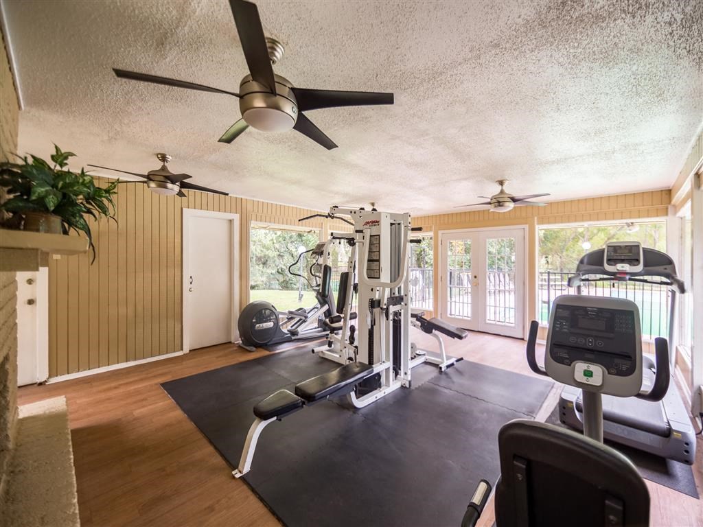 a home gym with a ceiling fan and exercise equipment
